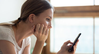 Frau mit Handy in der Hand wählt die 116117.