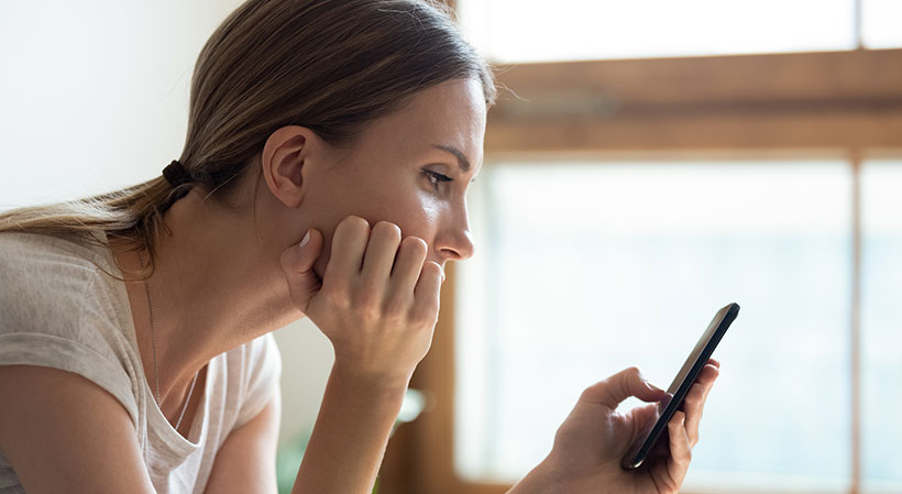 Frau mit Handy in der Hand wählt die 116117.