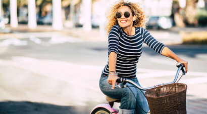 Das Bild zeigt eine junge Frau auf dem Fahrrad als Symbolbild für sportliche Aktivitäten im Frühling.